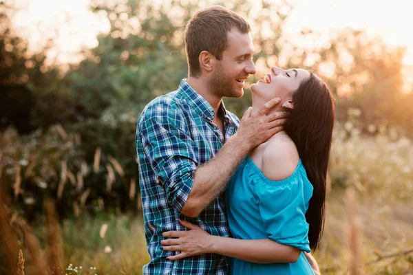 Elegante hermosa pareja joven de pie al aire libre en la luz del atardecer —  Fotos de Stock