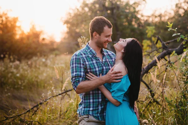 Élégant beau jeune couple debout à l'extérieur à la lumière du coucher du soleil — Photo