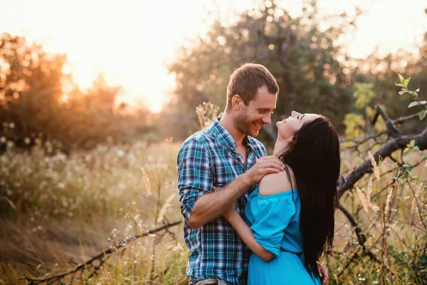 Élégant beau jeune couple debout à l'extérieur à la lumière du coucher du soleil — Photo