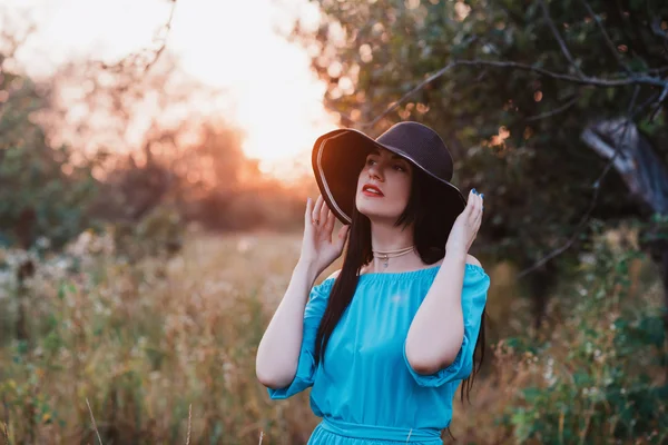 Портрет красивой девушки в шляпе в поле на закате — стоковое фото