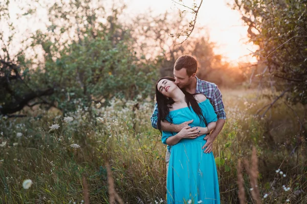 Elegante hermosa pareja joven de pie al aire libre en la luz del atardecer — Foto de Stock