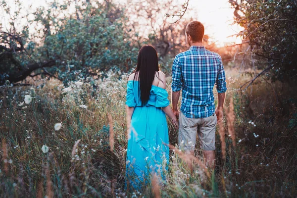 Romantische paar staande terug in de zonsondergang licht in het park, — Stockfoto