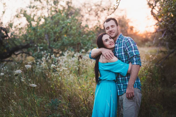 Elegante belo jovem casal em pé ao ar livre ao pôr do sol luz — Fotografia de Stock