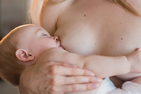 Young and beautiful mother breastfeeding baby