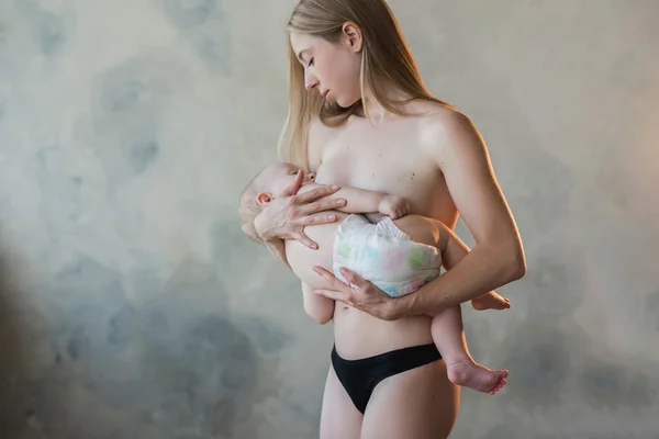 Junge und schöne Mutter beim Stillen — Stockfoto
