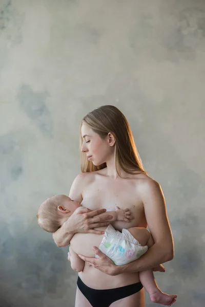 Young and beautiful mother breastfeeding baby — Stock Photo, Image