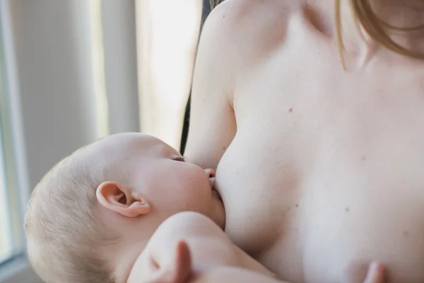 Young and beautiful mother breastfeeding baby — Stock Photo, Image