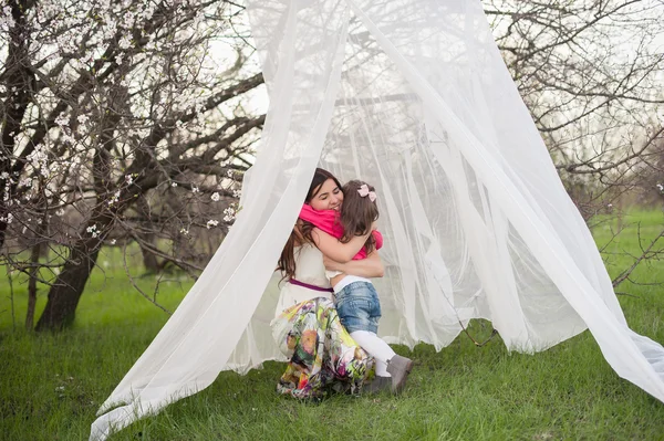 Mom kisses and hugs daughter on nature, family, motherhood, child — Stock Photo, Image