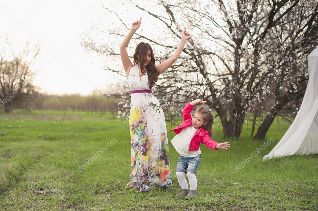 Mom and daughter dancing in nature together