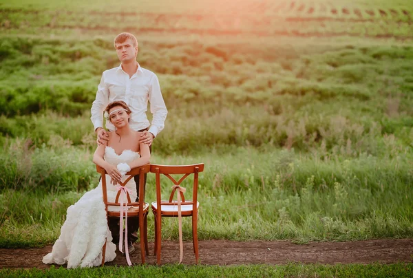 Krásná mladá nevěsta a ženich handicapované v západu slunce světlo — Stock fotografie