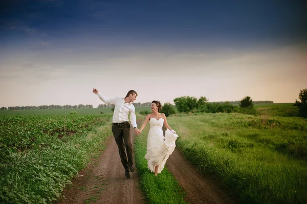 A noiva e o noivo vão e sorriem — Fotografia de Stock