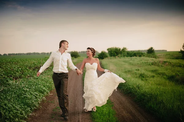 A noiva e o noivo vão e sorriem — Fotografia de Stock