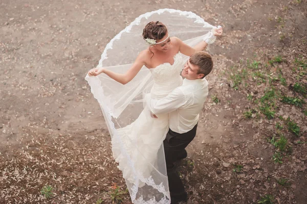 Вокруг жениха счастливая невеста в его объятиях на природе — стоковое фото