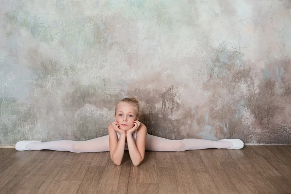 白い水着で分割の上に座って少しのバレエ ダンサー — ストック写真