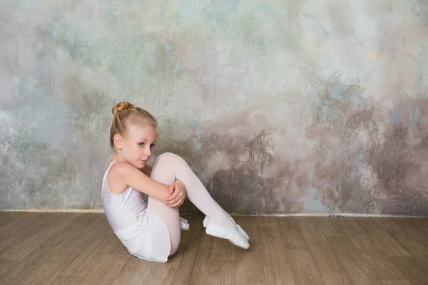 Little ballet dancer sitting white swimsuit, dance, sports, healthy lifestyle, ballet — ストック写真