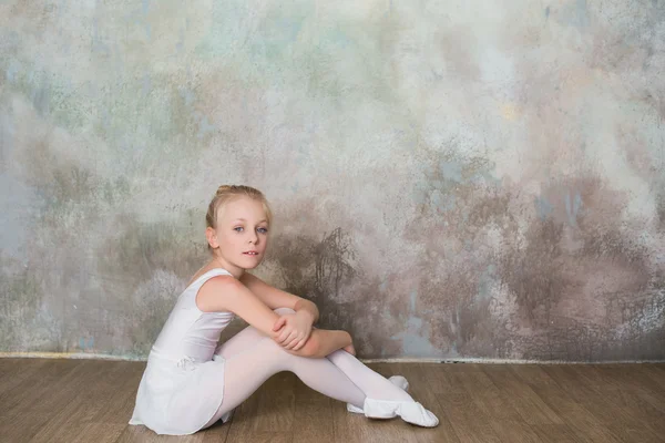 Little ballet dancer sitting white swimsuit, dance, sports, healthy lifestyle, ballet — Stock Photo, Image