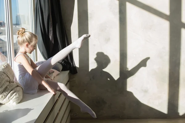 Little ballet dancer sitting white swimsuit
