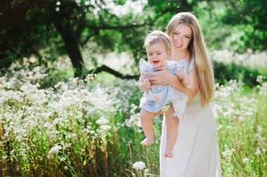 Genç anne küçük kızıyla birlikte doğa üzerinde oynama