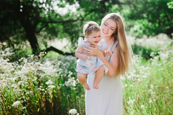 Joven madre jugando con su pequeña hija en la naturaleza —  Fotos de Stock