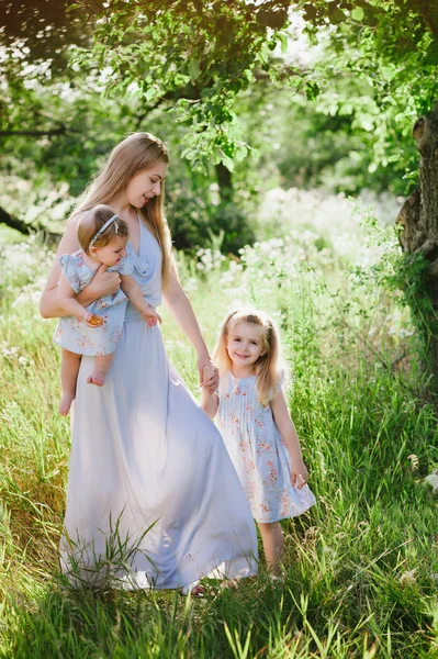 Mamma kramar två döttrar utomhus — Stockfoto