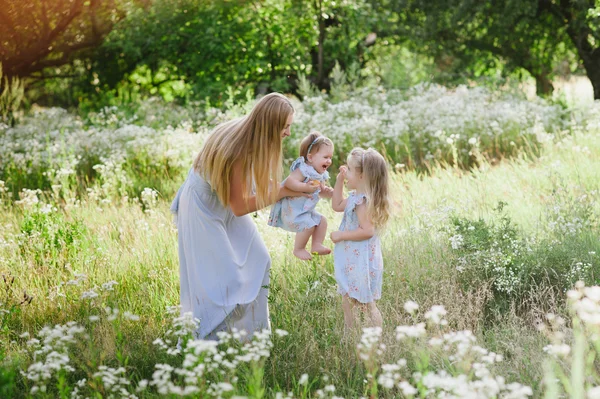 Mamá abrazando a dos hijas al aire libre —  Fotos de Stock