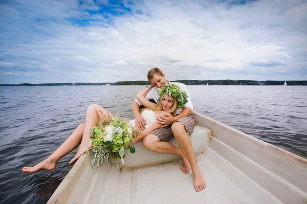 Joyeux jeune couple avec un bouquet et une couronne embrassant et embrassant — Photo