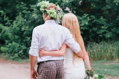 Bir buket ve kucaklayan ve öpüşme cenaze çelengi ile mutlu genç Çift