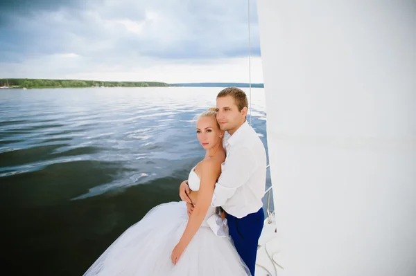 Happy bride and groom hugging on a yacht — Stock Photo, Image