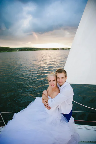 Happy bride and groom hugging on a yacht — Stock Photo, Image