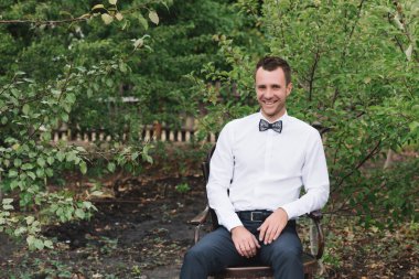 Bir beyaz gömlek ve papyon üzerinde doğa yakın çekim yakışıklı bir adam portresi