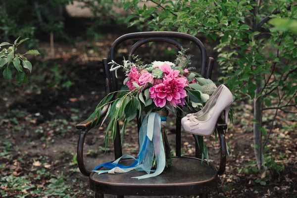 ハイヒールと性質のヴィンテージの椅子にカラフルな花の花束の美しい結婚式の靴 — ストック写真