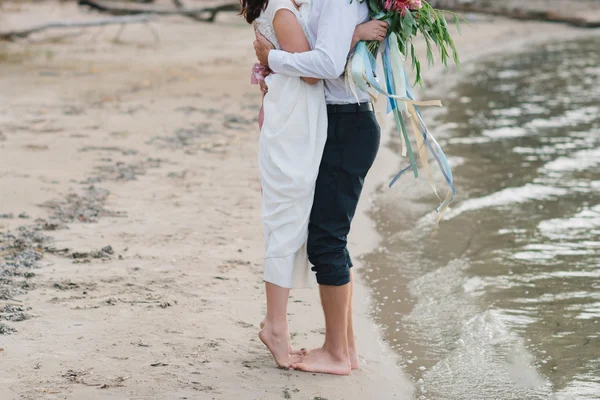 Jambes assez fort jeune couple affectueux sur la plage au-dessus de la rivière — Photo