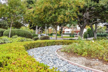 Beverly Gardens Park güzel çalılar, çiçek ve evin önünde taş kesilmiş