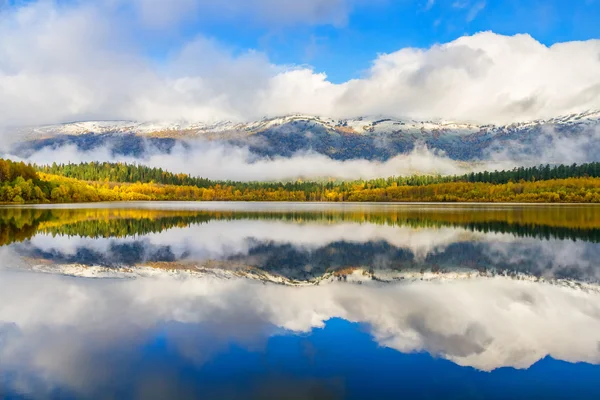 Lago en otoño nuboso montaña en el fondo — Foto de Stock