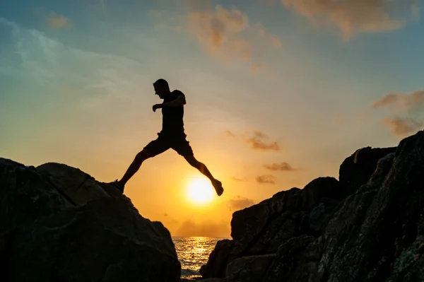 바다에 대 한 바위에 점프 하는 남자 — 스톡 사진