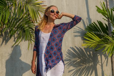 Yaz güneşli ve palmiye ağaçlarının arka plan üzerinde şık bir kız portresi