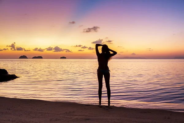 Силуэт молодой женщины, стоящей на пляже и смотрящей на закат на тропическом острове Самуи, Таиланд — стоковое фото