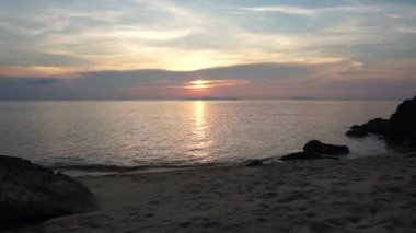 Genç çift beach izlerken günbatımı yürür