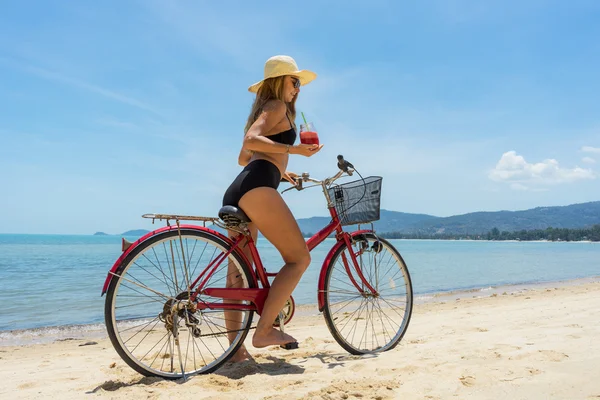 Jovem mulher andando de bicicleta em uma praia tropical — Fotografia de Stock