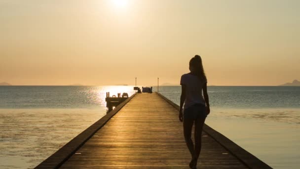 Young caucasian woman walking along the pier — Stock Video