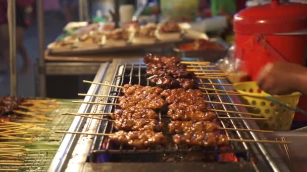 Las manos de la mujer cocinando comida callejera tailandesa pollo satay — Vídeos de Stock