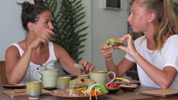 Due giovani donne scelgono il cibo nel menu e parlano in un caffè — Video Stock