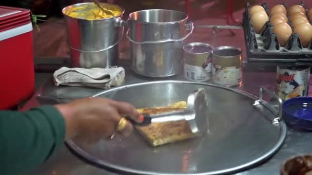 Las manos de la mujer cocinando panqueque tailandés de plátano comida callejera en Tailandia — Vídeos de Stock