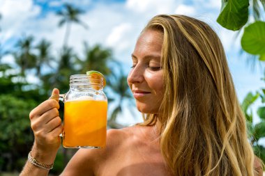 Taze meyve suyu bir kavanoz tutan genç kadın