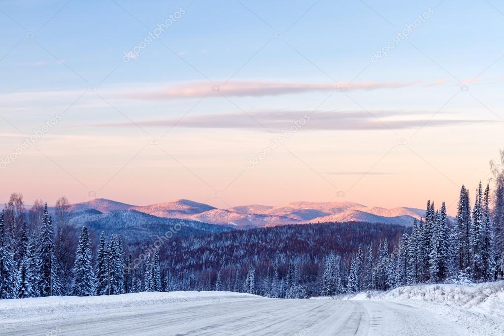 Road in the winter mountains in the background