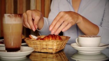 Kahve içen ve kafede kruvasan yiyen kadınlara yakın. 