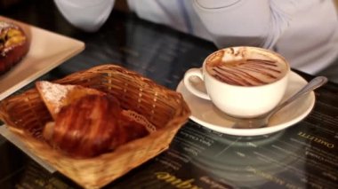 Kahve içen ve kafede kruvasan yiyen kadınlara yakın. 