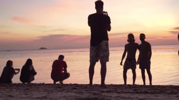 Folk Går Stranden Och Njuter Färgglada Solnedgången — Stockvideo