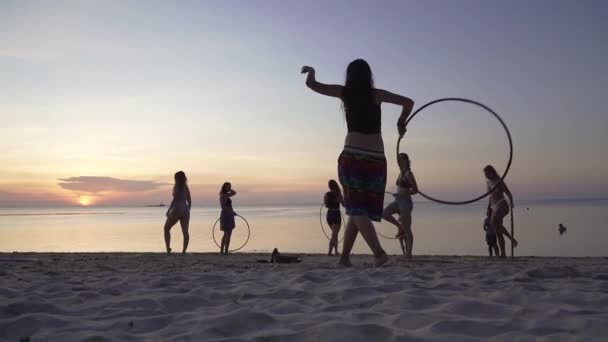 Silhouette Egy Fiatal Táncol Hula Karika Strandon Naplementekor Emberek Sétálnak — Stock videók