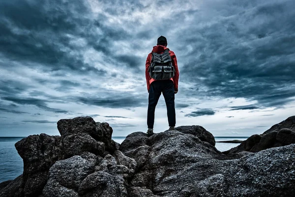 Man Red Jacket Backpack His Back Stands Sea Rocks Looks — Stock Photo, Image